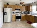 Well-lit kitchen with stainless steel appliances, light wood cabinets and tiled floors at 3645 Richland Dr, Columbus, IN 47203