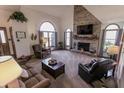 Comfortable living room with a fireplace, vaulted ceiling, large windows, and cozy seating at 3819 S Village Dr, New Palestine, IN 46163