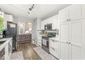 Well-lit kitchen with white cabinets, stainless steel appliances, and modern countertops, seamlessly connected to the living area at 4167 Apple Creek Dr, Indianapolis, IN 46235