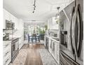 Bright kitchen featuring modern appliances, white cabinetry, hardwood floors, and an adjacent dining area at 4167 Apple Creek Dr, Indianapolis, IN 46235