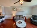 Cozy living room with hardwood floors, stylish furniture, a ceiling fan, and a decorative shelf at 4625 Woodcrest Dr, Columbus, IN 47203