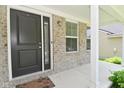 View of front porch showing front door, large sidelight window, and brick exterior at 5151 Climbing Rose Pl, Indianapolis, IN 46254