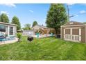 Spacious backyard featuring a wooden deck with seating area, fire pit, an above ground pool and shed at 580 Northgate Dr, Greenwood, IN 46143