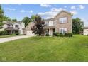 Charming two-story brick home featuring an attached two car garage and a well manicured front yard at 5852 Long Ridge Pl, Indianapolis, IN 46221