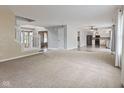 An open concept living room with plush carpet and connecting rooms with hardwood floors at 5852 Long Ridge Pl, Indianapolis, IN 46221