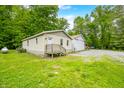 Cozy home with a welcoming front porch, nestled among trees, featuring a large metal outbuilding at 5858 N West Shore Dr, Morgantown, IN 46160