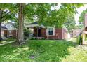 Quaint brick home with a well-maintained lawn and mature trees in a residential neighborhood at 6005 Winthrop Ave, Indianapolis, IN 46220