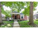 Charming single-story brick home with a covered porch and lovely landscaping at 6005 Winthrop Ave, Indianapolis, IN 46220