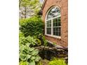 Attractive landscaping featuring a decorative pond, rocks and lush greenery near brick wall at 6307 Keeneland Ct, Indianapolis, IN 46278