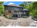Two story home features a stone patio with steps up to a deck and a landscaped area with mature trees at 6350 Red Oak Dr, Avon, IN 46123