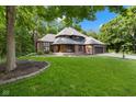 A lovely two-story brick home with mature trees, a well-maintained lawn, and an inviting covered porch at 6350 Red Oak Dr, Avon, IN 46123