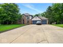 Long concrete driveway leading up to the two-car garage of this well-maintained, brick faced home at 6396 Granny Smith Ln, Avon, IN 46123