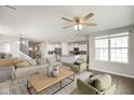 Spacious living room with open floor plan, hardwood floors, ceiling fan, comfortable furniture, and stairs leading to the upper level at 6830 Park Grove Blvd, Whitestown, IN 46075