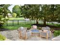 Backyard patio with Adirondack style chairs, fire pit, and string lights, all surrounded by a lush green lawn at 6862 Riverside Way, Fishers, IN 46038