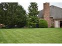 Spacious backyard featuring lush lawn, mature trees, and rod iron fence at 6862 Riverside Way, Fishers, IN 46038