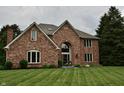 Lovely brick home featuring a manicured front lawn and arched entryway at 6862 Riverside Way, Fishers, IN 46038
