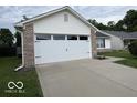 Spacious two-car garage with a clean, concrete driveway and tidy landscaping at 7022 Cordova Dr, Indianapolis, IN 46221