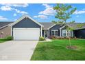 Well-maintained single Gathering home with attached garage, lush lawn, and tasteful landscaping at 7184 Lillian Pl, Cumberland, IN 46229