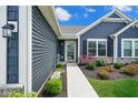 Inviting front walkway leading to home with stone accents and vibrant landscaping at 7184 Lillian Pl, Cumberland, IN 46229