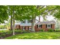 Attractive home with a brick and siding facade, surrounded by lush greenery and mature trees on a well-kept lawn at 7935 N County Road 650 E, Brownsburg, IN 46112