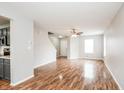 Open-concept living room featuring hardwood floors, ceiling fan and neutral color palette at 9220 Crossing Dr, Fishers, IN 46037