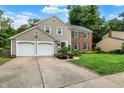 Attractive two-story home with a two-car garage, a well-kept lawn, and a basketball hoop on the side at 9302 Budd Run Dr, Indianapolis, IN 46250