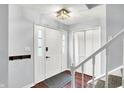 Inviting foyer featuring hardwood floors, a coat closet, and a staircase leading to the upper level at 9302 Budd Run Dr, Indianapolis, IN 46250