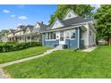 Lovely home showcases a well manicured lawn and inviting front porch with great curb appeal at 938 N Tuxedo St, Indianapolis, IN 46201