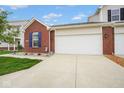 Two-car garage with brick accents and vinyl siding, complete with a concrete driveway and tidy lawn at 9682 Angelica Dr, Noblesville, IN 46060