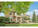Beautiful brick home with manicured lawn, mature trees, and inviting covered porch at 9833 Parkshore Dr, Fishers, IN 46038