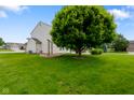 Spacious backyard with well-kept lawn, mature trees providing ample shade, and a cozy patio area at 101 Meadowview Dr, Mooresville, IN 46158