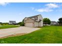 Shot of a two-story home with an attached garage, long driveway, and a well-manicured front yard at 101 Meadowview Dr, Mooresville, IN 46158