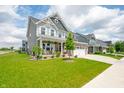 Attractive two-story home boasts a covered front porch, stone accents, and well-manicured landscaping at 1026 Woodglen Dr, Westfield, IN 46074