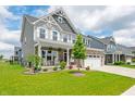 Attractive two-story home boasts a covered front porch, stone accents, and well-manicured landscaping at 1026 Woodglen Dr, Westfield, IN 46074
