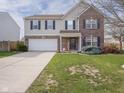 Charming two-story home with a well-manicured lawn, attached garage, and tasteful fall decorations at 10443 Ringtail Pl, Fishers, IN 46038