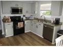 Well-lit kitchen with granite countertops, stainless steel appliances, and white cabinets at 10443 Ringtail Pl, Fishers, IN 46038