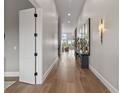 Hallway with light hardwood floors, white trim, decor, and white doors at 10655 E 200 S, Zionsville, IN 46077