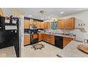 Functional kitchen with black appliances, wooden cabinets, and ample counter space for meal preparation at 11614 Gosling Dr, Indianapolis, IN 46229