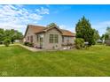 Well-maintained home exterior featuring lush landscaping and a cozy sunroom at 1202 Orphant Annie, Greenfield, IN 46140