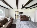 Spacious living room featuring stylish gray flooring, exposed beam ceilings, and abundant natural light at 1206 Mcdougal St, Indianapolis, IN 46203