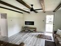 Bright living room boasts exposed beam ceilings, recessed lighting, and stylish gray flooring at 1206 Mcdougal St, Indianapolis, IN 46203