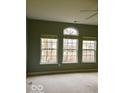 Spacious bedroom with neutral walls, three large windows, and cozy carpet at 1280 Shadow Ridge Rd, Indianapolis, IN 46280