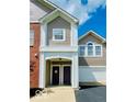 Inviting townhome featuring an attached garage, brick accents, and a covered porch entrance at 1280 Shadow Ridge Rd, Indianapolis, IN 46280