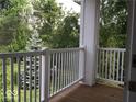 Private patio with wooden floor and white railing overlooking mature trees and lush green lawn at 1280 Shadow Ridge Rd, Indianapolis, IN 46280
