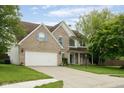 Beautiful exterior view of this two-story home with a two-car garage and a inviting front porch at 15409 Heath Cir, Westfield, IN 46074