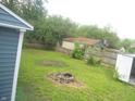 Large grassy backyard with wood fence, fire pit, and detached shed at 1732 N Ritter Ave, Indianapolis, IN 46218