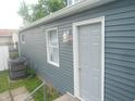 Exterior features gray siding, white trim, updated window, and access door at 1732 N Ritter Ave, Indianapolis, IN 46218
