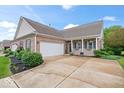 Charming brick home with an attached garage, inviting front porch, and well-manicured landscaping at 1905 Persimmon Grove Dr, Indianapolis, IN 46234