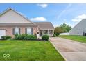 Well-maintained brick home with a green lawn, neat landscaping, and a charming front porch at 1905 Persimmon Grove Dr, Indianapolis, IN 46234