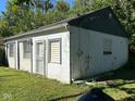 Side exterior view of a small building with siding of white cinder blocks and painted green boards on a sunny day at 1920 Kildare Ave, Indianapolis, IN 46218